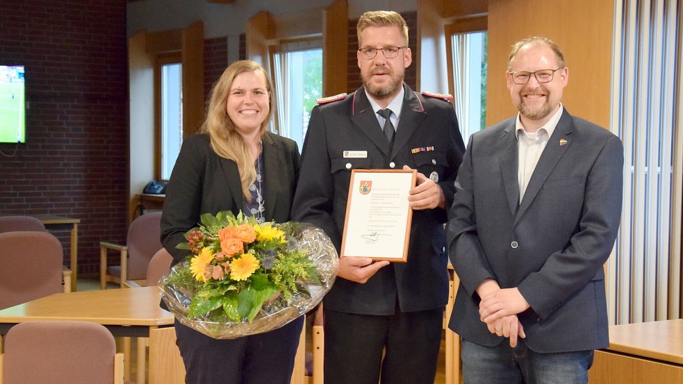 Hartmut Hanekamp (Mitte) hört als Gemeindebrandmeister im Saterland auf. Das Foto stammt aus dem Jahr 2021. Damals wurde Hanekamp zum Gemeindebrandmeister ernannt. Bürgermeister Thomas Otto überreichte ihm die Ernennungsurkunde. Links im Bild ist Janine Hanekamp zu sehen. Foto: Thomas Giehl/Feuerwehr Saterland