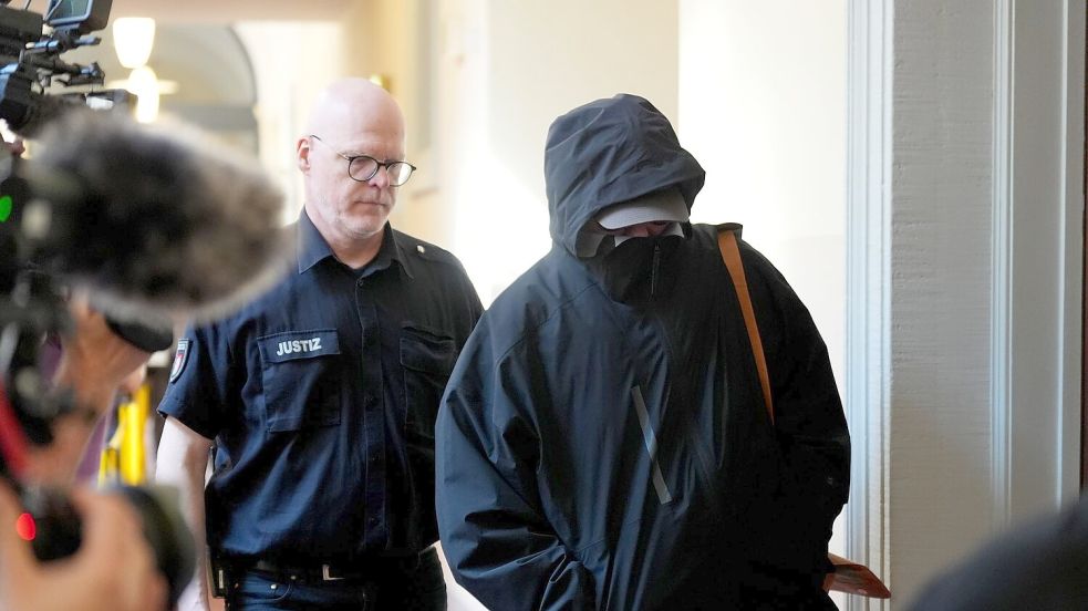Ein Angeklagter wird von einem Polizisten zum Gerichtssaal begleitet. Foto: Marcus Brandt/dpa