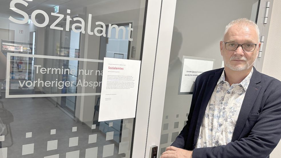 Ostrhauderfehns Bürgermeister Günter Harders steht vor dem Sozialamt seiner Gemeinde. Ein Zettel in der Tür informiert über die Situation: Besuche und Telefonate sind nicht möglich. Foto: Marion Janßen