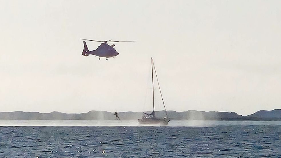Mit dem Hubschrauber wird ein Notfallsanitäter auf dem Segelboot vor Spiekeroog abgesetzt. Foto: DGzRS