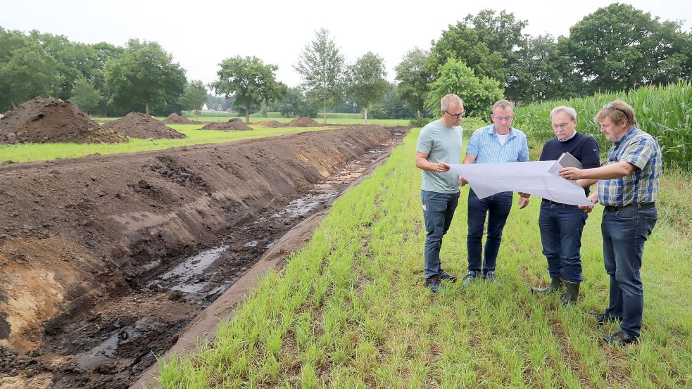 Bei einer Baubesprechung warfen (von links) Timo Schnau, Thomas Theilmann (Caritas), Ing. Heinrich Addicks und Bauamtsleiter Hans Schulte einen Blick in den Plan für die Verlegung des Entwässerungsgrabens. Foto: Hans Passmann