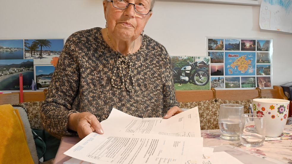 Elfriede Brandt mit den Dokumenten, die ihr von der Gemeinde Schiffdorf zugestellt wurden. Die Schiffdorferin wird hier über die Einsatzberichte der Feuerwehr informiert. Auch die Einsatzkosten sind hier vermerkt. Foto: Scheschonka