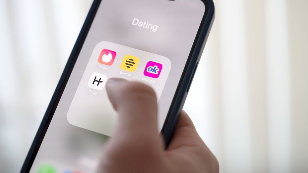 Eine Frau hält ein Smartphone, auf dem Dating-Apps angezeigt werden. (Symbolbild) Foto: Alicia Windzio/dpa