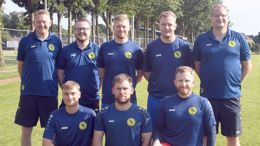 Beim SC Rhauderfehn-Langholt freuen sich Trainer Gerd Bartsch (links), Betreuer Daniel Deeken (daneben) und Co-Trainer Gerd Stubbe. (rechts) über die Neuzugänge Jaques Herzog (Mitte oben), Jonas Schipper (oben, Zweiter von rechts), Max Schultheis (ab vorne von links), Christopher Rehmer und Lars Nordbrock. Foto: Hans Damm