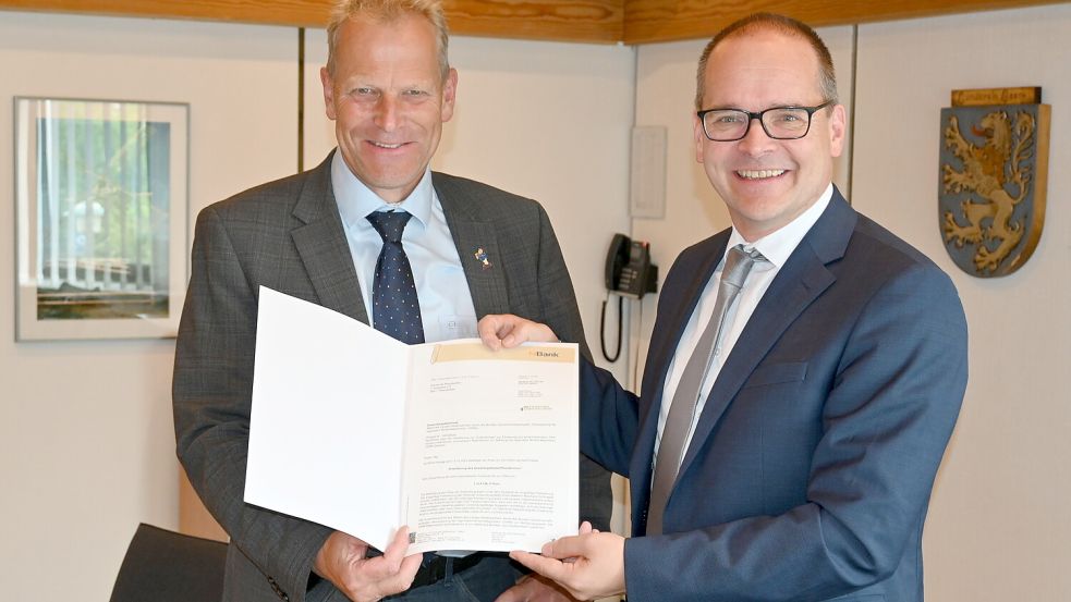 Große Freude bei der Gemeinde Rhauderfehn: Niedersachsens neuer Wirtschaftsminister Grant Hendrik Tonne (rechts) überreichte den Förderbescheid für das neue Gewerbegebiet in Rhaudermoor an Bürgermeister Geert Müller. Foto: Holger Weers