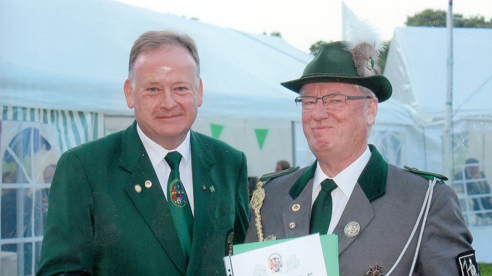 Ehrungen und Auszeichnungen gehören auf dem Schützenfest in Glansdorf traditionell dazu. Das Foto zeigt Detlef Temmen (Präsident des Ostfriesischen Schützenbundes, links), der Hanko Weers für langjährige Mitgliedschaft auszeichnet. Foto: Verein