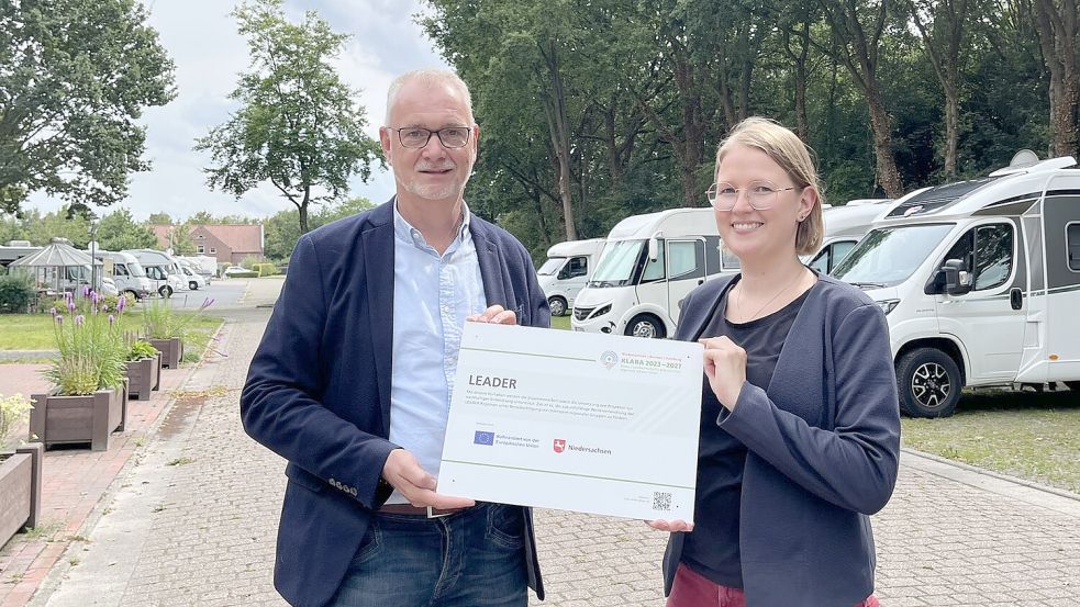Regionalmanagerin Daniela Kirschstein übergibt symbolisch den Bewilligungsbescheid an Bürgermeister Günter Harders. Foto: Gemeinde Ostrhauderfehn