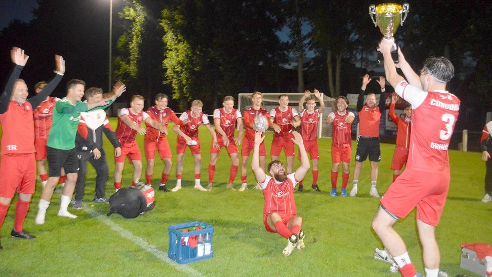 Jubelnd reckt Ihrhoves Mannschaftskapitän Baran-Ömer Saracoglu (rechts) den Wanderpokal in die Höhe. Die Teamkollegen (vorne sitzend: der Dreifachtorschütze Arlind Jonjic) feiern mit. Foto: Holger Weers