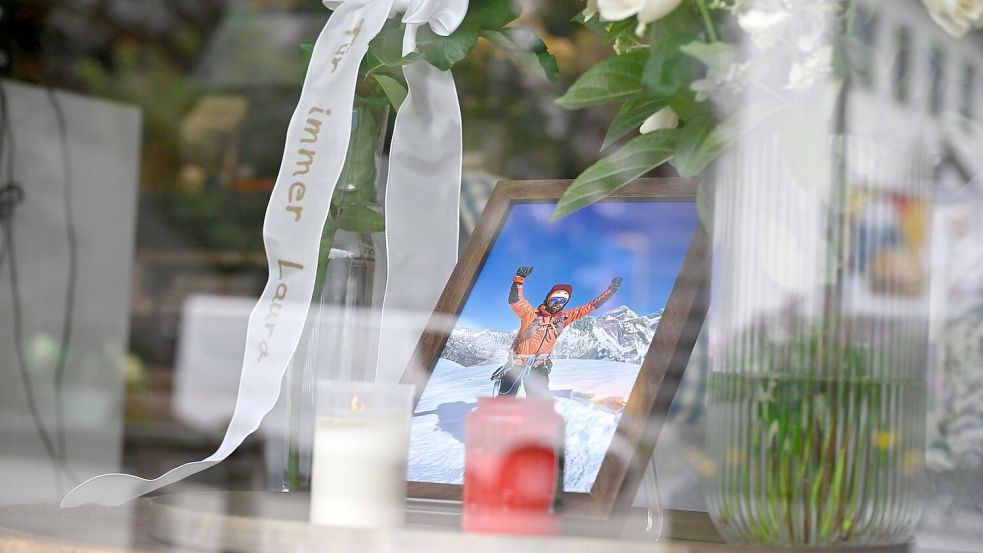 in Foto, Kerzen, Rosen und eine Schleife mit der Aufschrift „Für immer Laura“ stehen im Einrichtungsgeschäft Dahlmeier im Schaufenster. Foto: Uwe Lein/dpa