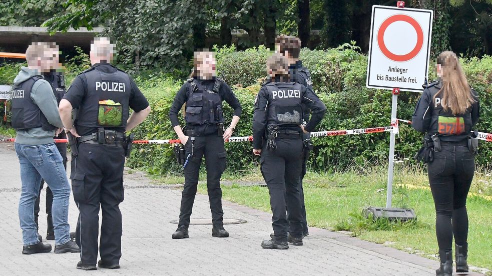 Polizeibeamte besprechen nach der Doppel-Tat gegen Klinik-Mitarbeiter von Heide die Lage. Ermittlungen wegen versuchten Mordes laufen. Foto: Ulrich Seehausen