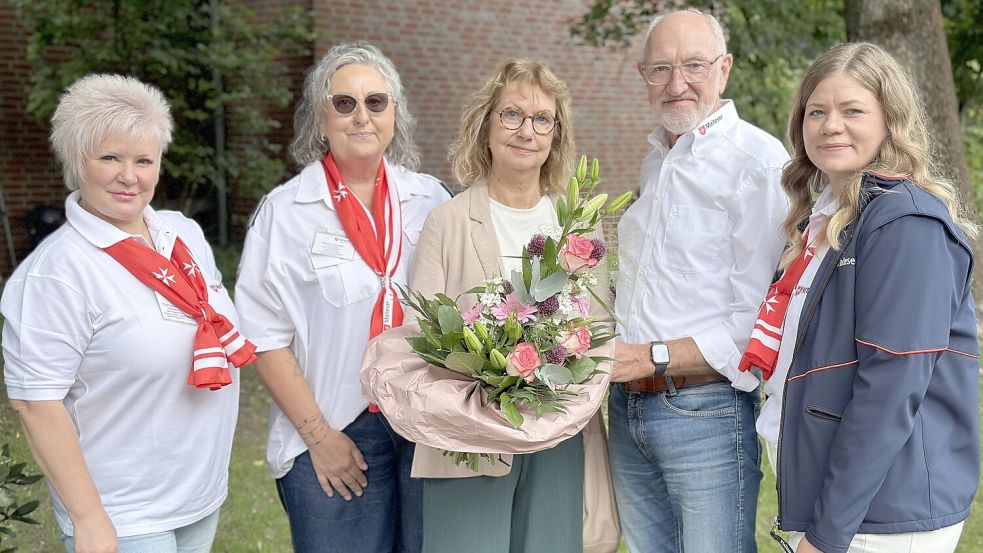 Blumen zum Einstieg: Malteser-Stadtbeauftragter Gerd Dumstorff überreicht Christa Berssen (Mitte) als 100. Ehrenamtliche im Beisein der Koordinatorin Olga Lambricht, Dienststellenleiterin Marlen Schmidt und Koordinatorin Miriam Tebben-Fastje (von links) einen bunten Strauß. Foto: Claudia Wimberg