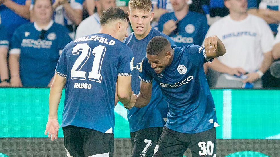 Isaiah Young und Stefano Russo jubeln über das entscheidende 1:0 für Bielefeld. Foto: Bernd Thissen/dpa
