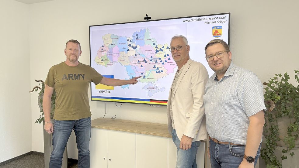 Michael Kröger (von links) stellte im Beisein der Bürgermeister Günter Harders und Nils Anhuth das Projekt „Leben retten 2025!“ vor. Im Hintergrund ist eine Landkarte der Ukrainie zu sehen. Foto: Horst Kruse