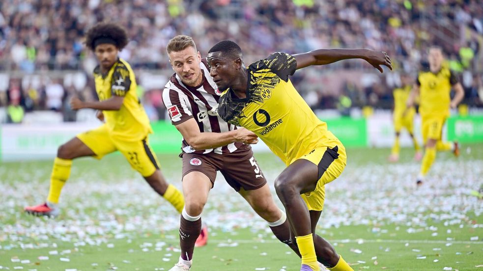 St. Paulis Hauke Wahl (l) im Zweikampf mit BVB-Stürmer Serhou Guirassy. Foto: Sina Schuldt/dpa