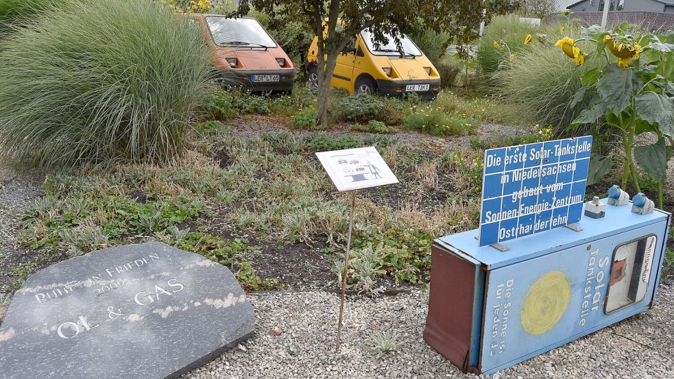 Die erste Stromtankstelle Niedersachsens dient inzwischen als Zeitzeuge und Museumsstück. Links daneben liegt ein symbolischer Grabstein mit großer Aussagekraft: „Ruhet in Frieden Öl und Gas“.