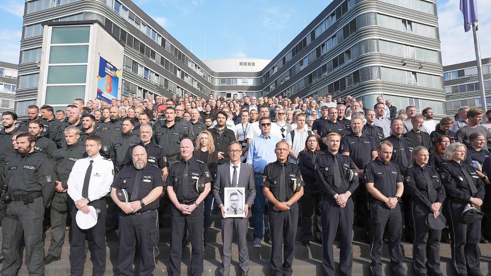 Das saarländische Innenministerium hatte die Polizeibehörden der anderen Länder und des Bundes eingeladen, sich der Gedenkminute anzuschließen. Hier zahlreiche Beamte vor dem Polizeipräsidium in Hamburg. Foto: Marcus Brandt/dpa