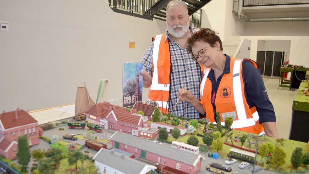 Olaf und Anja Schremb aus dem Westoverledinger Ortsteil Ihren kümmern sich um die Fehntjer Kleinbahn im Modell. Hier stehen sie vor dem früheren Bahnhof in Westrhauderfehn im Maßstab 1:87. Voriges Jahr ist die Anlage umgezogen ins Leeraner Miniaturland. Bald sollen dort wieder Züge rollen. Foto: Astrid Fertig