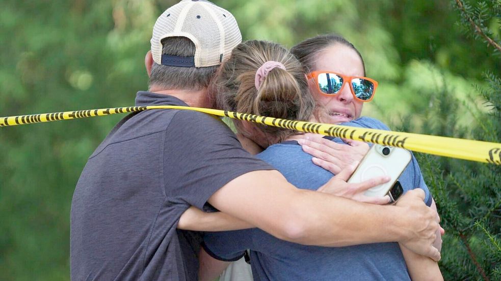 Menschen umarmen sich nach Schüssen an einer Schule, bei denen zwei Kinder gestorben sind. Foto: Alex Kormann/Star Tribune/AP/dpa