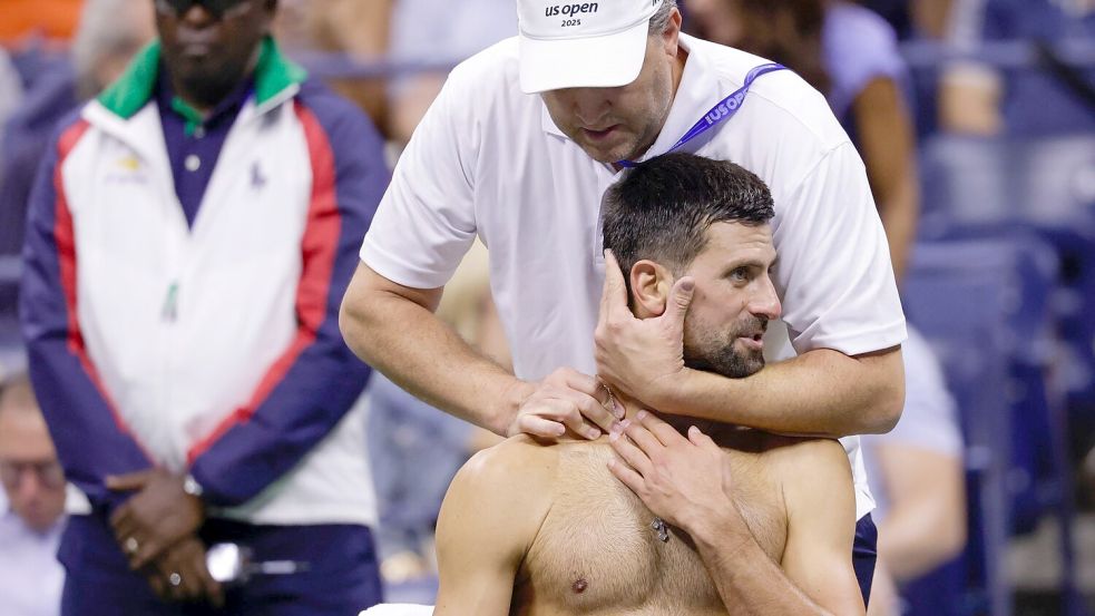 Novak Djokovic ließ sich nach dem ersten Satz im Nacken - und Schulterbereich behandeln. Auch nach dem zweiten Satz rief er den Physiotherapeuten. Foto: Andres Kudacki/AP/dpa