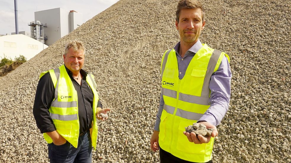Zum Wiederverwerten aus Beton: Manfred Janssen (links) und Maximilian Ueberschaar präsentieren Recycling-Schotter für den Fahrbahnunterbau.