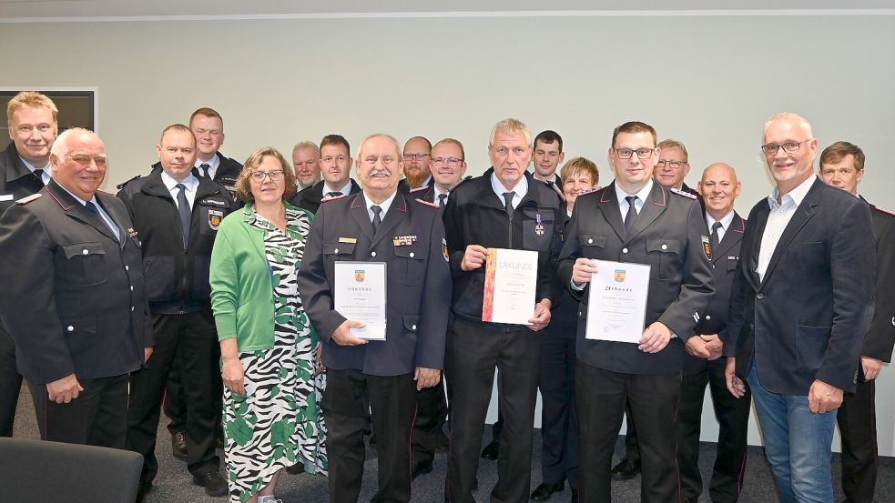 Mit Uwe Wagner (Ernennung zum Ehrengemeindebrandmeister), Andreas Erbo (Auszeichnung mit Deutschem Feuerwehr-Ehrenkreuz in Silber) und Alexander Wittmann (stellvertretender Gemeindebrandmeister) erhielten gleich drei Feuerwehrkamderaden aus der Gemeinde Ostrhauderfehn Urkunden aus unterschiedlichen Anlässen. Das Foto zeigt die Geehrten (von links vorne) Uwe Wagner mit Ehefrau Marlene, Andreas Erbo und Alexander Wittmann sowie Ostrhauderfehns Bürgermeister Günter Harders. Foto: Holger Weers