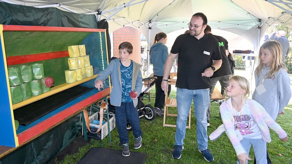Kinder probieren ihr Glück beim Dosenwerfen – eine der Stationen auf dem Gemeindefest. Foto: Holger Weers