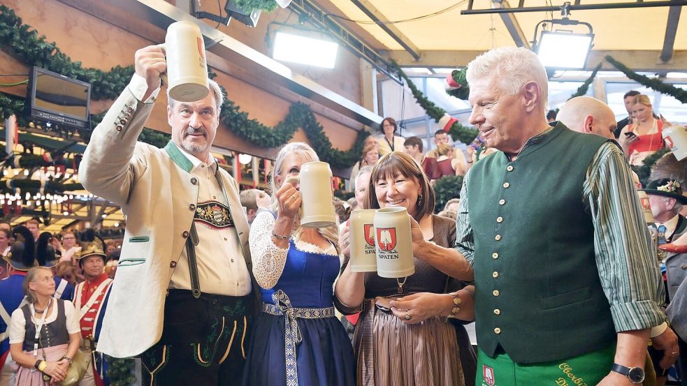 Bayerns Ministerpräsident Söder (l.) und Münchens OB Reiter (r.) stoßen mit ihren Ehefrauen auf eine friedliche Wiesn an. Foto: Peter Kneffel