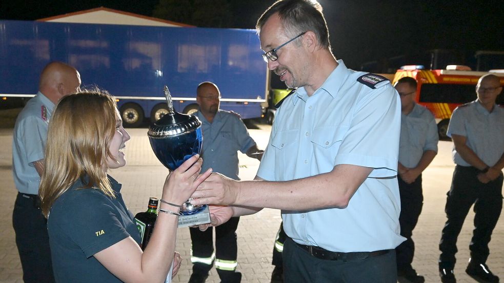Stolz nimmt Tiana Freesemann (links), Gruppenführerin aus Großwolde, den Wanderpokal aus den Händen von Ihrhoves Ortsbrandmeister Frank Eden (rechts) entgegen. Foto: Holger Weers