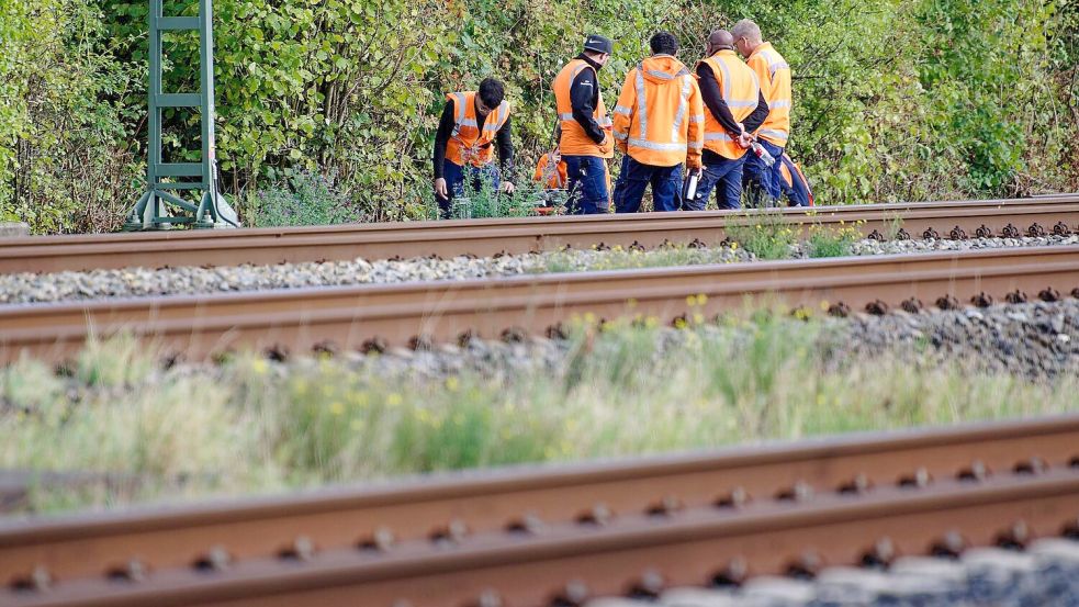 Bahn-Mitarbeiter stehen am Rand der Strecke Köln-Düsseldorf. Foto: Henning Kaiser