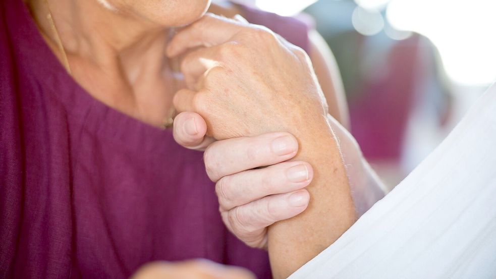 Eine Frau hält die Hand ihres an Demenz erkrankten Mannes. Foto: Daniel Naupold/dpa