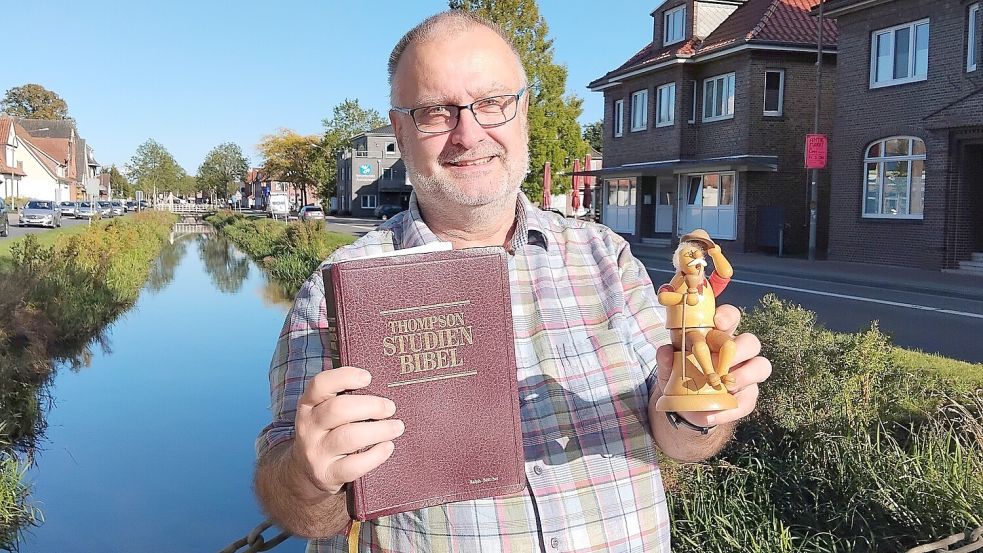 Ralph Böttcher mit seinen beiden festen Lebensankern in der Hand: Bibel und Räuchermännchen. Foto: Clarissa Scherzer