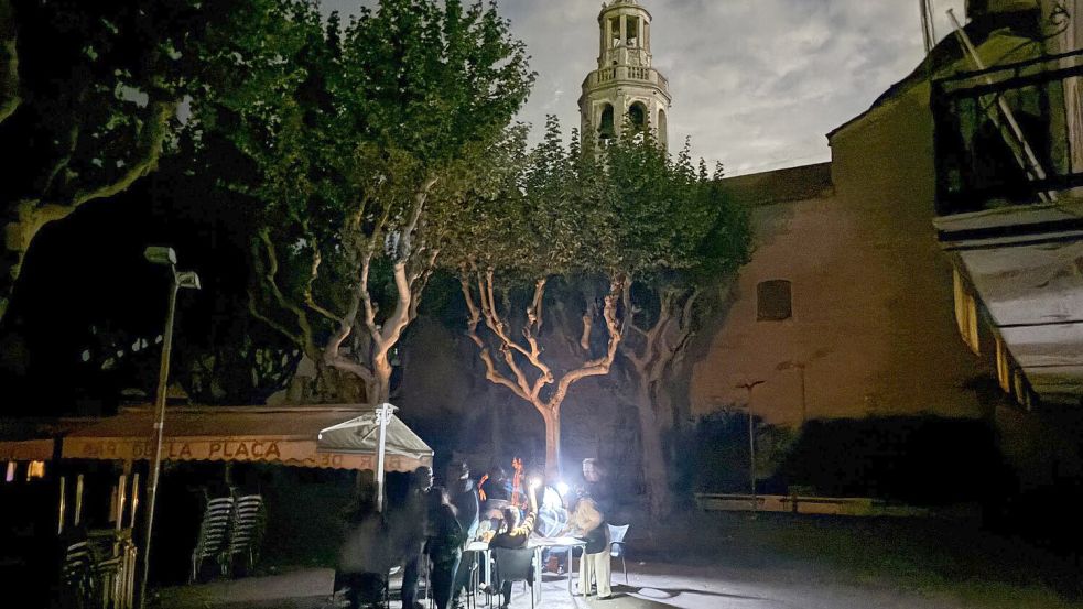 Während des Blackouts sitzen Gäste eines Straßencafés in der Kleinstadt Premià de Mar bei Barcelona im Licht von Taschenlampen und trinken lauwarmes Bier. (Archivbild) Foto: Jan-Uwe Ronneburger/dpa
