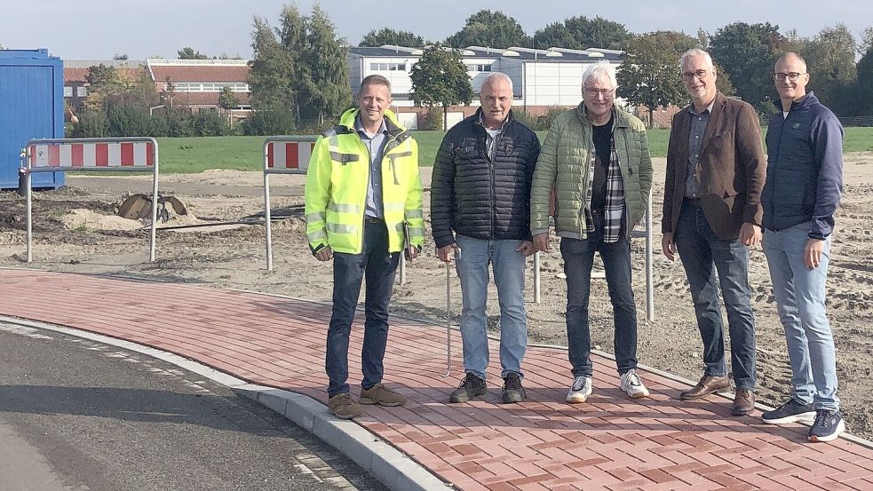 Heino de Freese (Ingenieurbüro Kremer Klärgesellschaft), Jens Zimmermann (Ludwig Würdemann Tiefbau GmbH), Uwe Zimmermann (Ingenieurbüro Kremer Klärgesellschaft), Bürgermeister Günter Harders und Guido Meyer (Fachbereichsleiter Planen und Bauen) bei der Abnahme der neuen Verbindungsstraße. Foto: Gemeinde Ostrhauderfehn
