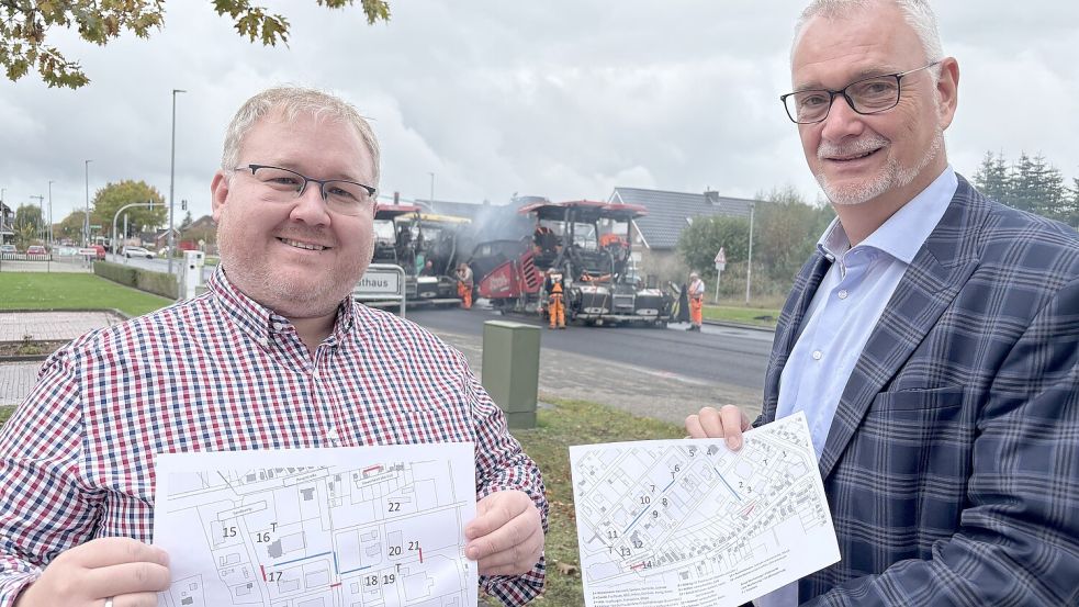 Marktmeister Heiko Tinnemeyer (links) und Bürgermeister Günter Harders präsentieren den Standplan für das Straßenfest. Im Hintergrund ist die Baustelle zu sehen. Foto: Dirk Hellmers