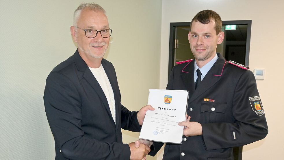 Bürgermeister Günter Harders (links) überreichte Dennis Wachsmann die Ernennungsurkunde zum stellvertretenden Ortsbrandmeister von Holterfehn. Foto: Holger Weers