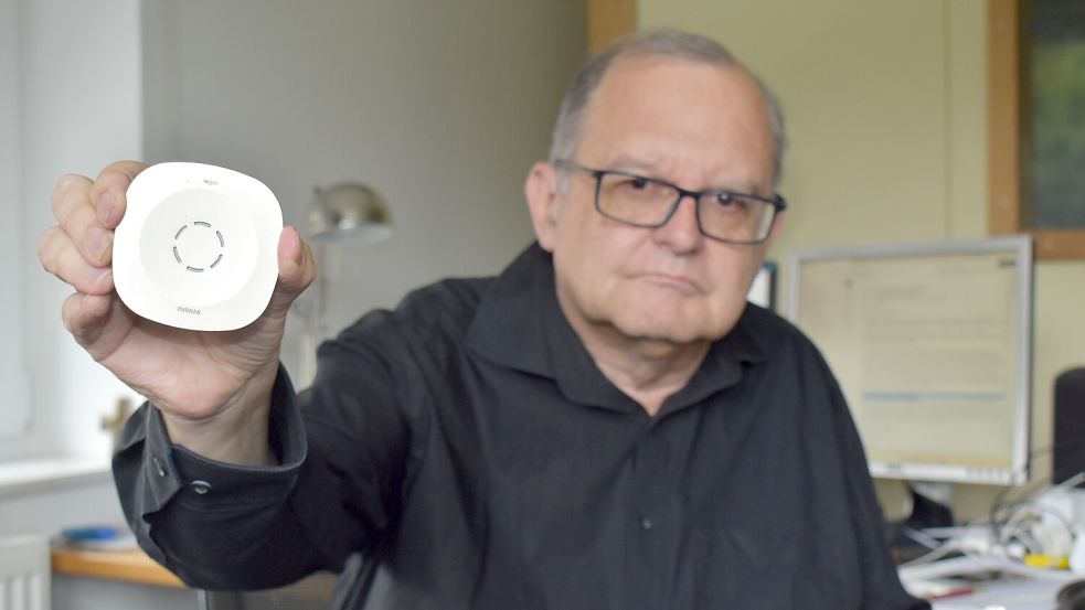 Der Journalist Peter Welchering hält ein Tischmikrofon in der Hand. Dieses technische Hilfsmittel ermöglicht es dem Schwerhörigen, auch in größeren Räumen zu hören. Seine Krankenkasse will die Kosten für die Anschaffung des Geräts nicht übernehmen.