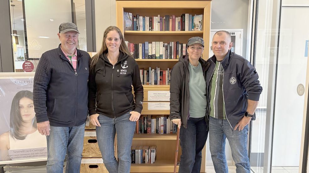Wolfgang Erfurth (von links), Jessica Beld, Maria Zörgiebel und Oliver Zörgiebel vor dem öffentlichen Bücherregal im Eingangsbereich vom Combi-Markt in der Rhauderwieke. Foto: Madita Janßen