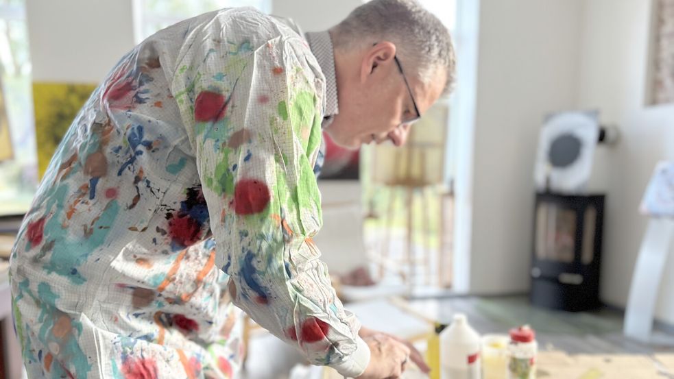 Helmut ter Hazeborg in seinem bunten Maleranzug beim Farben anmischen. Foto: Madita Janßen