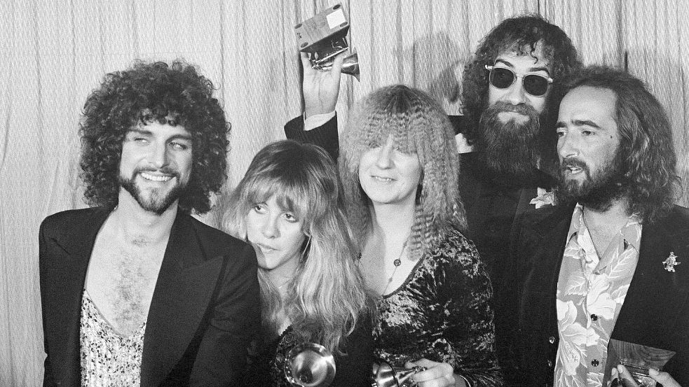 Lindsey Buckingham (l-r), Stevie Nicks, Christine McVie, Mick Fleetwood und John McVie, Mitglieder der Rockgruppe Fleetwood Mac, posieren mit ihrem Grammy Award für das Album des Jahres „Rumours“. Foto: Richard Drew/AP/dpa
