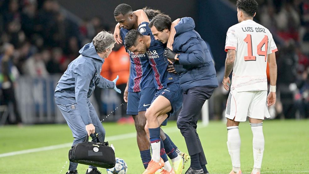 Auf Betreuer gestützt wird der am Fuß verletzte PSG-Spieler Achraf Hakimi (M) vom Platz geführt. Foto: Federico Gambarini