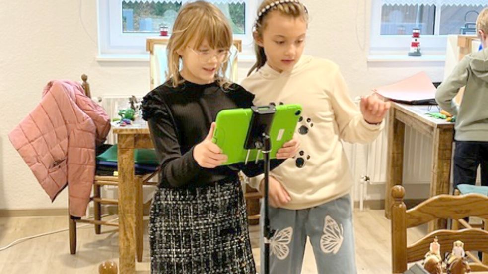 Alisa und Marie-Sophie fotografieren mit dem Tablet eine Szene für ihren Film. Foto: Hinrich Heselmeyer