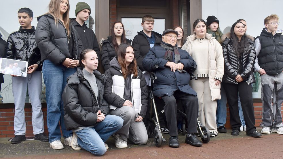 Albrecht Weinberg vor seinem Geburtshaus am Untenende in Rhauderfehn mit Schülern der Erich Kästner Schule. Sie hatten die Gedenkfeier mit organisiert. Foto: Henrik Zein