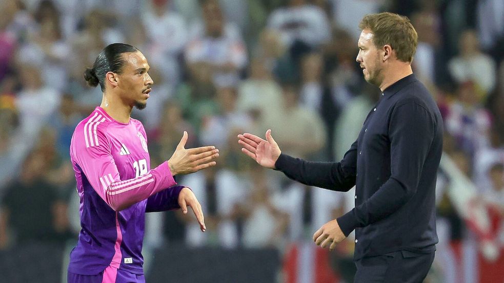 Leroy Sané (l) und Julian Nagelsmann klatschen nach einem Spiel ab. (Archivbild) Foto: Christian Charisius