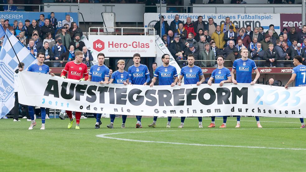 Beim vergangenen Spiel zwischen dem SV Meppen und Kickers Emden liefen die Mannschaften mit dem Banner „Aufstiegsreform“ ein. Foto: imago/Jens Doden
