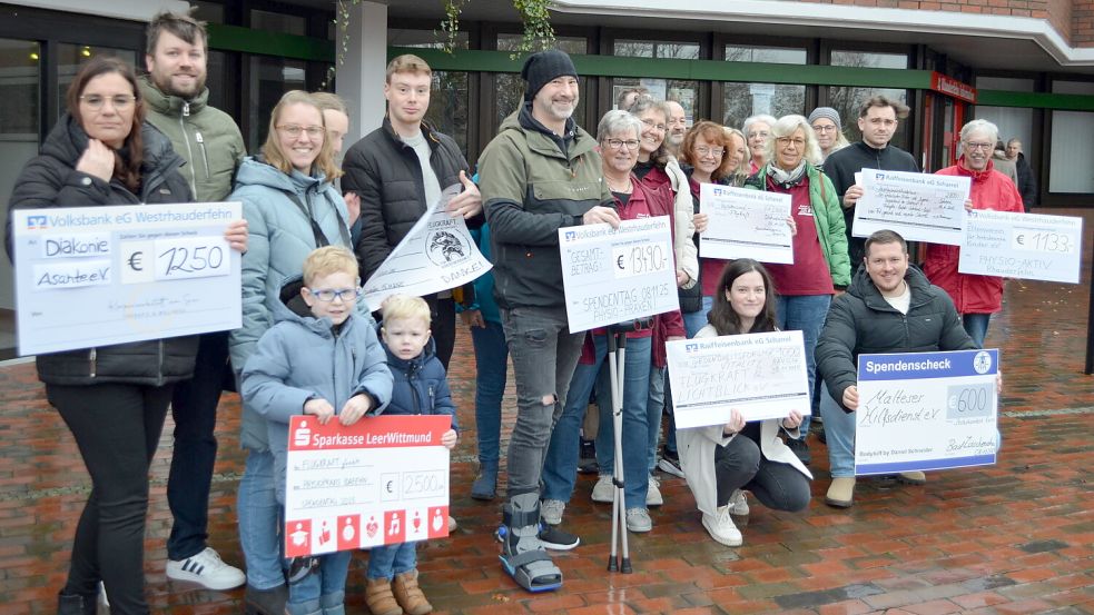 Eine Gesamtsumme von 14.600 Euro hat der diesjährige Massage-Aktionstag erbracht, zu dem der Rhauderfehner Physiotherapeut Timo Möhlmann (vorne mit Scheck und Krücken) aufgerufen hatte. Die neun teilnehmenden Praxen entschieden individuell, welchen Verein sie mit dem eingenommenen Spendengeld unterstützen. Foto: Astrid Fertig
