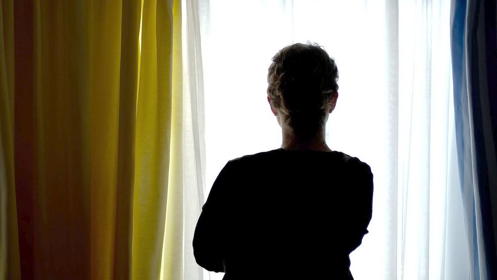 Eine junge Frau steht in einem Zimmer eines Frauenhauses. Bald steht der Tag zur Beendigung der Gewalt gegen Frauen an. Foto: Peter Steffen/dpa