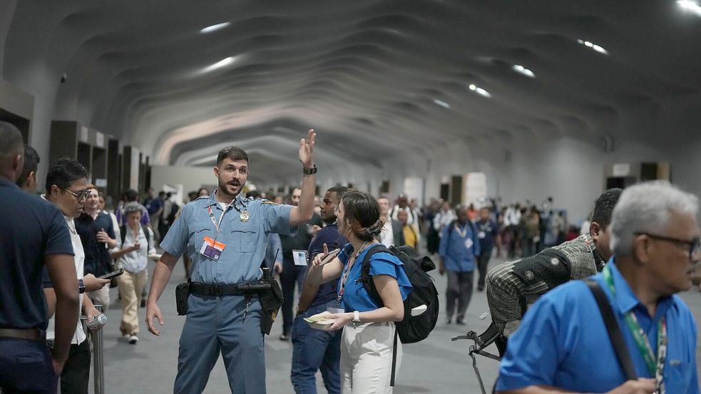 Menschen verlassen das Gelände der Weltklimakonferenz COP 30 wegen eines Feuers. Foto: Fernando Llano/AP/dpa