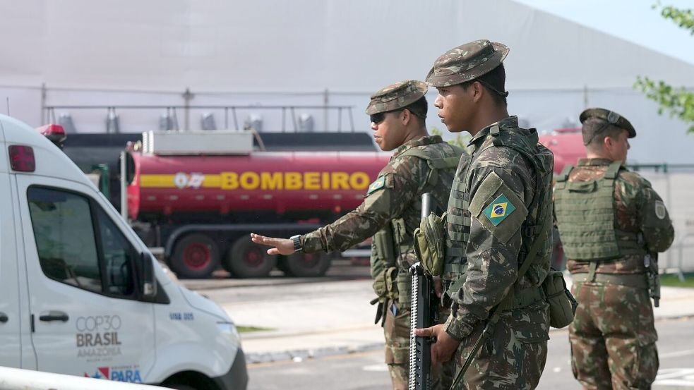 Sicherheitskräfte leiten Fahrzeuge nach einem Brand auf dem Gelände der Weltklimakonferenz. Foto: Fernando Llano/AP/dpa
