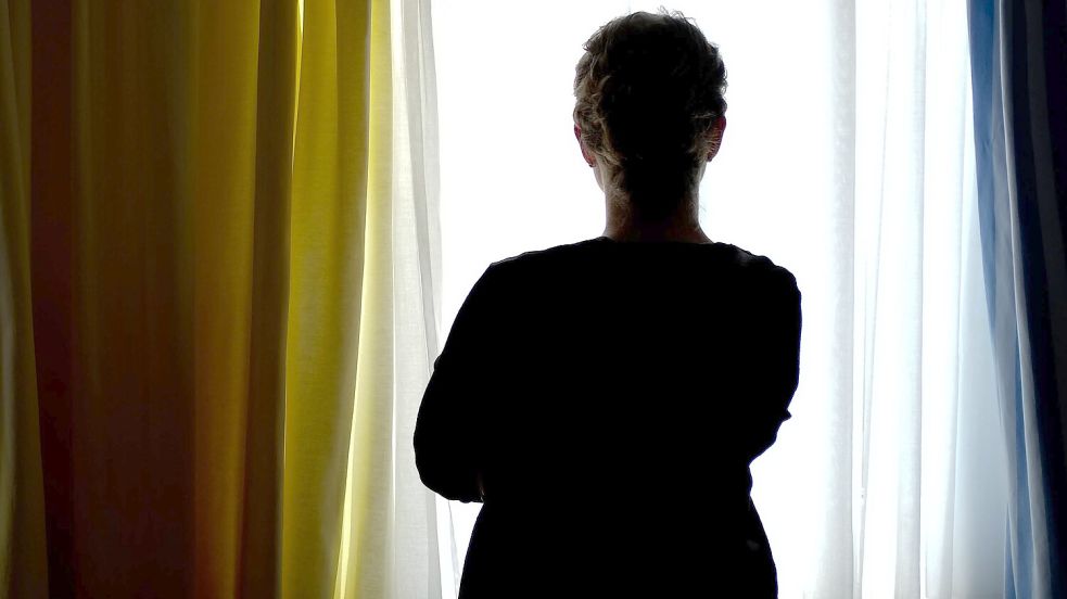 Eine junge Frau steht in einem Zimmer eines Frauenhauses. Der Absprung aus einer gewaltvollen Beziehung ist schwer. Foto: Peter Steffen/dpa