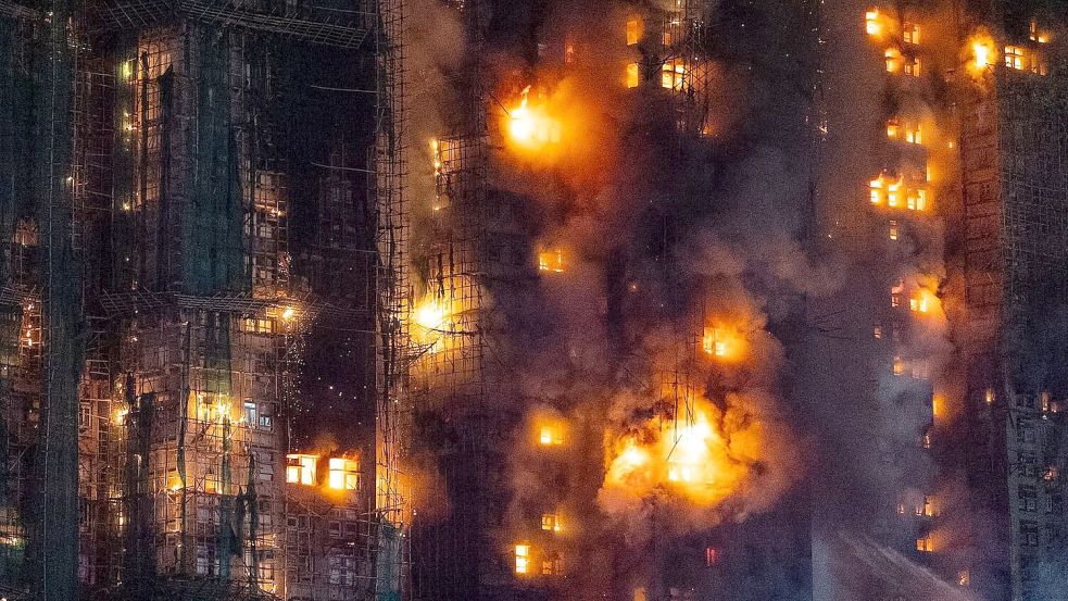 Fotos und Videos vom Einsatzort zeigten große Rauchschwaden, die aus den eingerüsteten Wohnhochhäusern aufstiegen. Foto: Chan Long Hei/AP/dpa